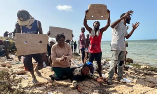 Migrants beg for help as they gather at an area near the Libya-Tunisia border